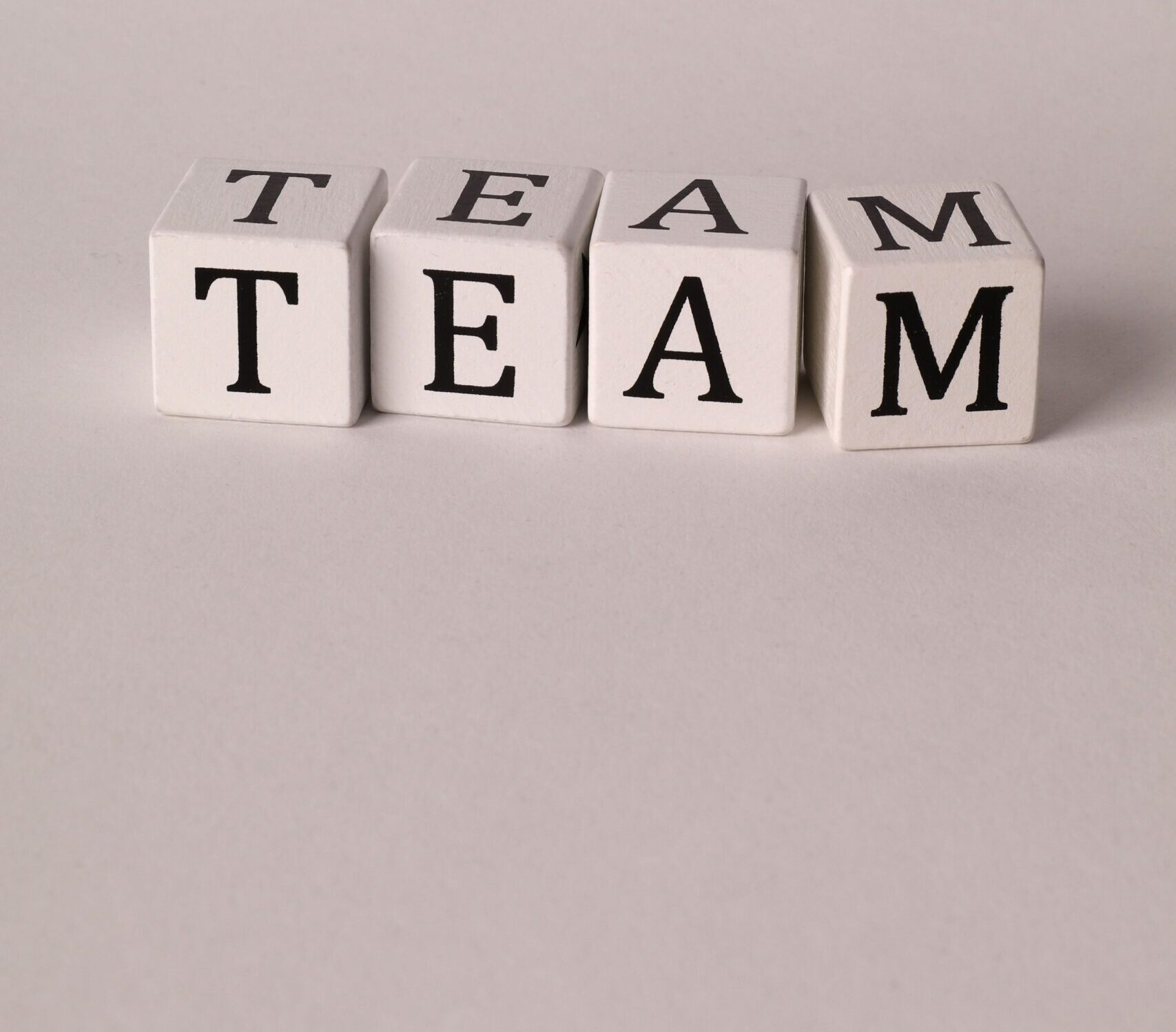 Buchstabenwürfel, die das Wort „TEAM“ bilden.